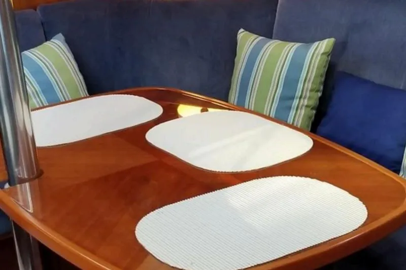 Slide: The Image of Interior of 1998 Beneteau Oceanis 352 with wooden table and striped cushions. - 17