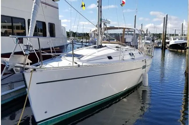 Slide: The Image of 1998 Beneteau Oceanis 352 sailboat docked in a marina, clear sky background. - 2