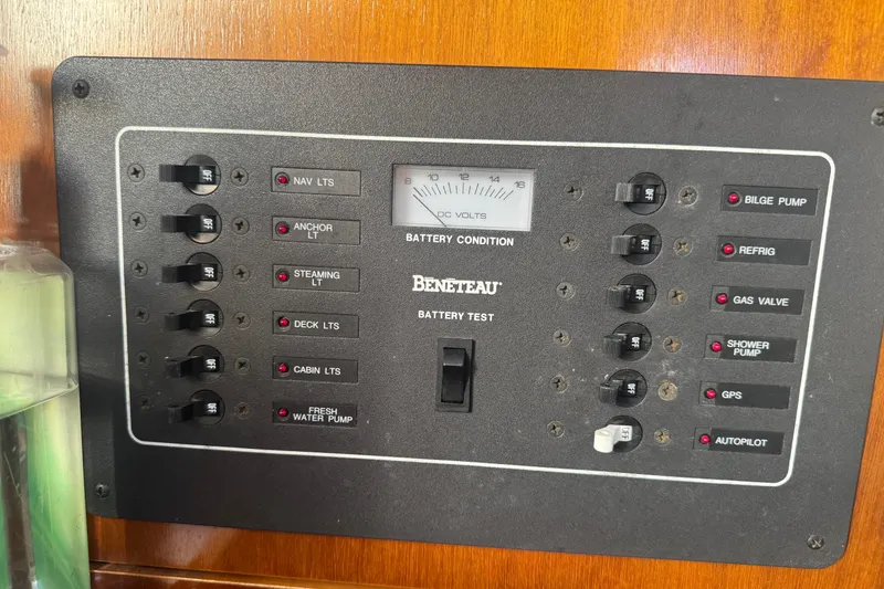 Slide: The Image of Control panel of a 1998 Beneteau Oceanis 352 sailboat, featuring various switches and battery gauge. - 22