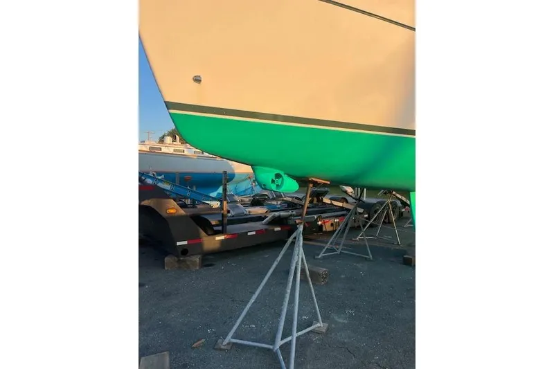Slide: The Image of 1998 Beneteau Oceanis 352 sailboat on stands, green hull, in a boatyard. - 38