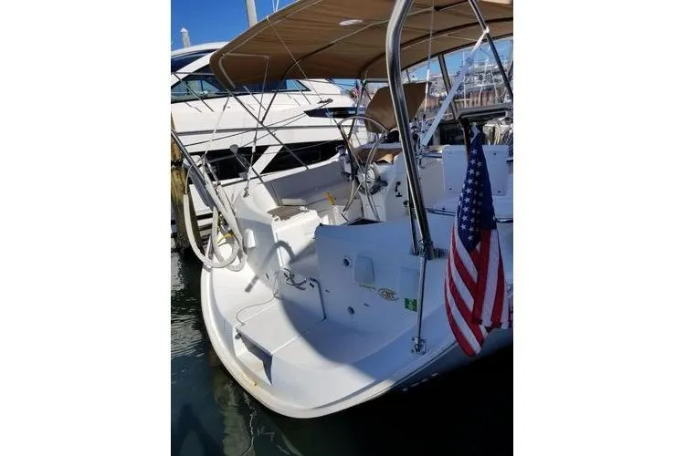 Slide: The Image of 1998 Beneteau Oceanis 352 sailboat docked, featuring a spacious cockpit and American flag. - 4