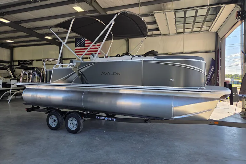 Slide: The Image of 2026 Avalon LSZ 2185 Cruise Rear Bench pontoon boat in showroom, on trailer. - 1