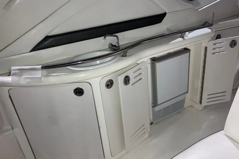 Slide: The Image of 2003 Sea Ray 420 Sundancer interior with cabinets and a small refrigerator. - 24