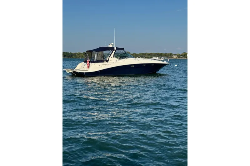 Slide: The Image of 2003 Sea Ray 420 Sundancer yacht on calm water under clear blue sky. - 45