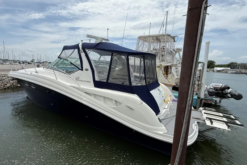 Slide: The Image of 2003 Sea Ray 420 Sundancer yacht docked at marina under cloudy sky. - 18