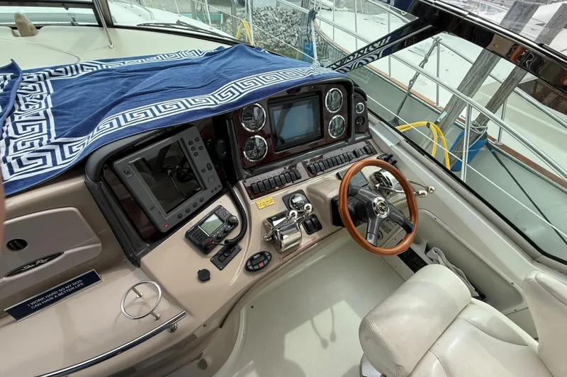 Slide: The Image of Helm of 2003 Sea Ray 420 Sundancer with navigation equipment and wooden steering wheel. - 26