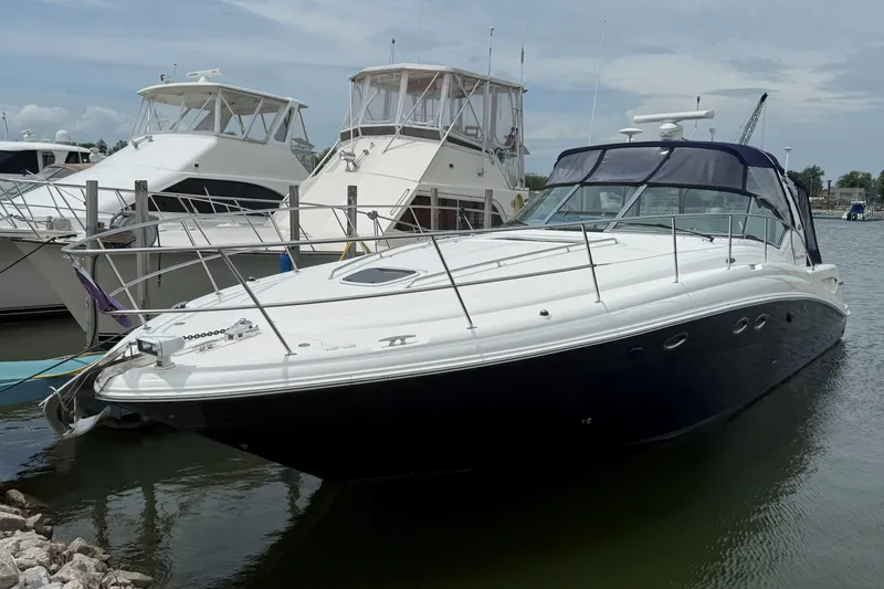 Slide: The Image of 2003 Sea Ray 420 Sundancer yacht docked at marina, featuring sleek design and spacious deck. - 3