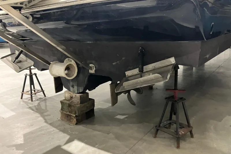 Slide: The Image of 2003 Sea Ray 420 Sundancer boat on stands, showing propeller and rudder details. - 13