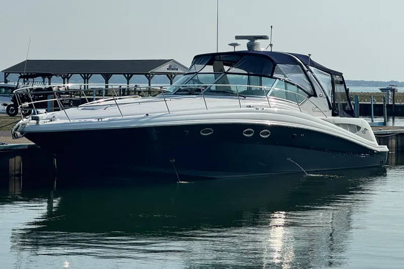 The Image of 2003 Sea Ray 420 Sundancer yacht docked at marina, sleek design, calm water reflection. - 0