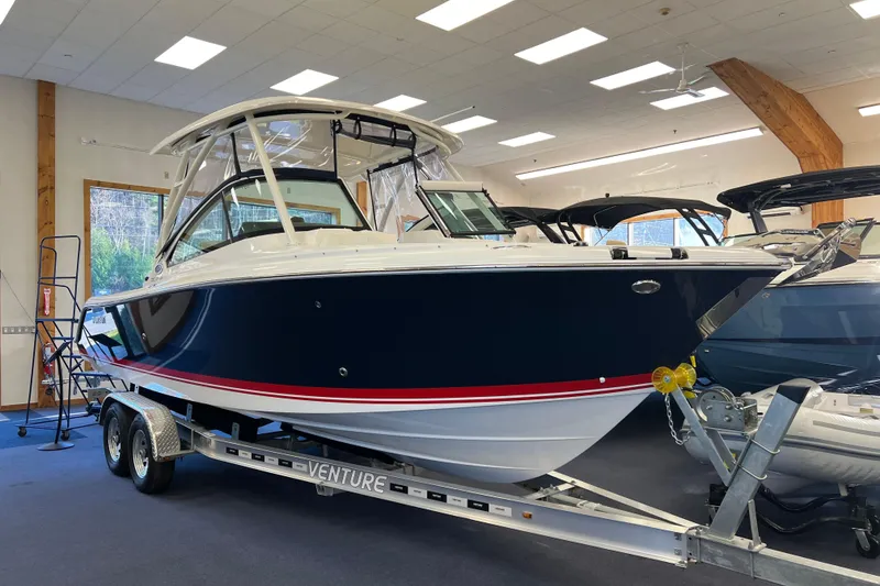 The Image of 2025 Pursuit DC 246 Dual Console boat on trailer in showroom. - 0