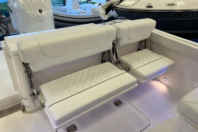 Slide: The Image of 2025 Pursuit DC 246 Dual Console boat with white cushioned seating and elegant interior design. - 10