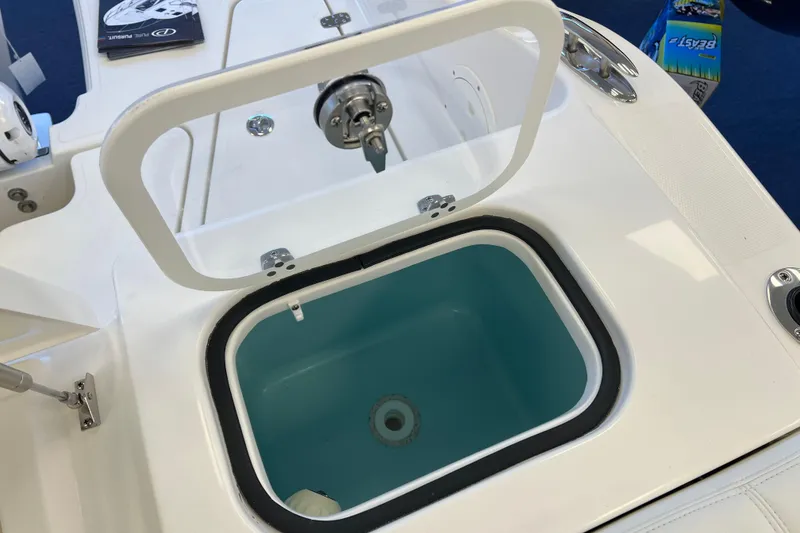 Slide: The Image of 2025 Pursuit DC 246 Dual Console boat with open storage compartment. - 12
