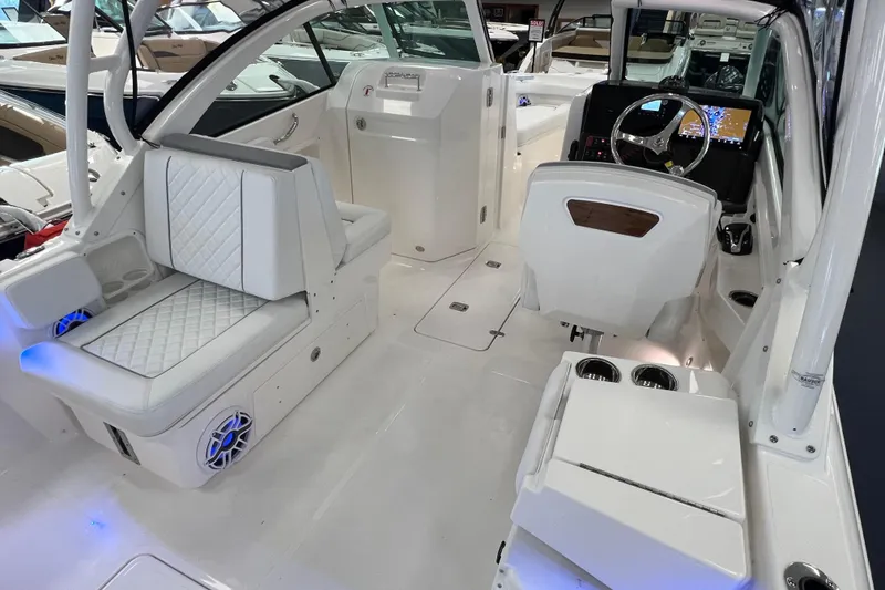 Slide: The Image of 2025 Pursuit DC 246 Dual Console boat interior with white seating and modern dashboard. - 13