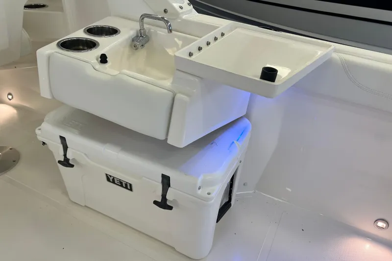 Slide: The Image of 2025 Pursuit DC 246 Dual Console boat sink and Yeti cooler setup. - 14