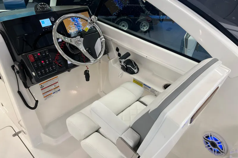 Slide: The Image of 2025 Pursuit DC 246 Dual Console boat cockpit with steering wheel and control panel. - 20