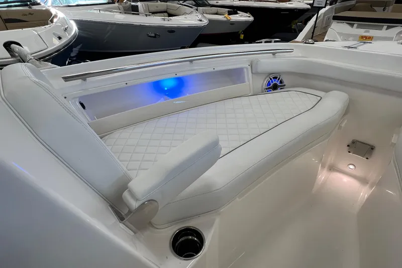 Slide: The Image of 2025 Pursuit DC 246 Dual Console boat interior with white cushioned seating and blue LED lighting. - 32
