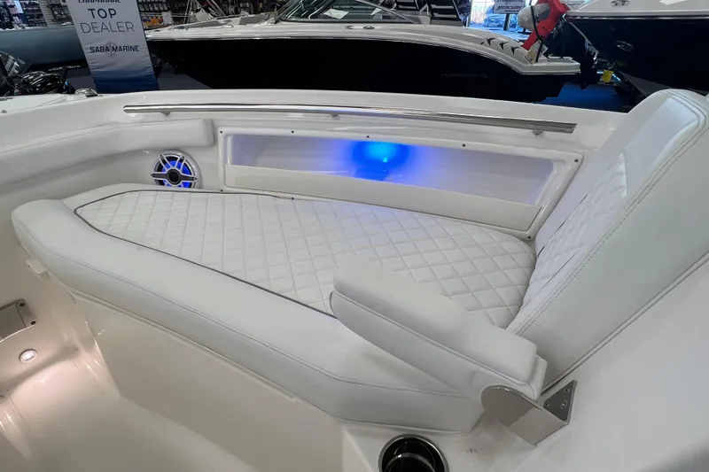 Slide: The Image of 2025 Pursuit DC 246 Dual Console boat interior with white quilted seating and blue LED lighting. - 33