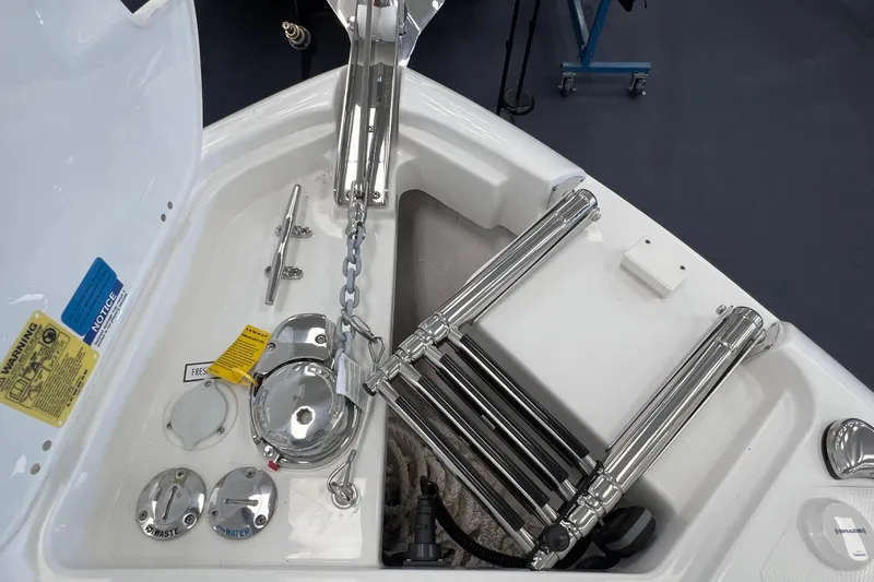 Slide: The Image of 2025 Pursuit DC 246 Dual Console boat anchor compartment with ladder and chain. - 34