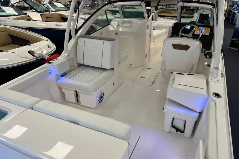 Slide: The Image of 2025 Pursuit DC 246 Dual Console boat interior with white seating and modern dashboard. - 5