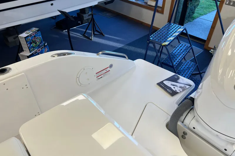 Slide: The Image of 2025 Pursuit DC 246 Dual Console boat interior with manual, ladder, and accessories. - 7