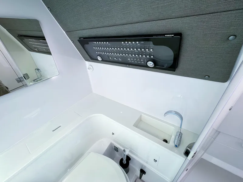 Slide: The Image of 2024 Axopar 37XC CROSS CABIN bathroom with modern sink and control panel. - 16
