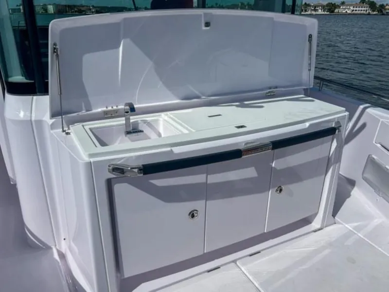 Slide: The Image of 2024 Axopar 37XC CROSS CABIN outdoor kitchenette with sink and storage. - 20