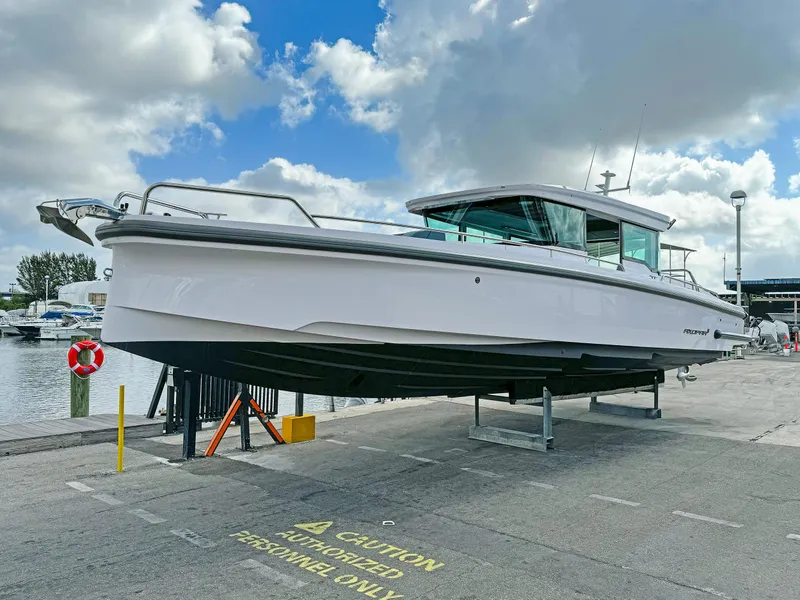 Slide: The Image of 2024 Axopar 37XC CROSS CABIN boat on dock under cloudy sky. - 22