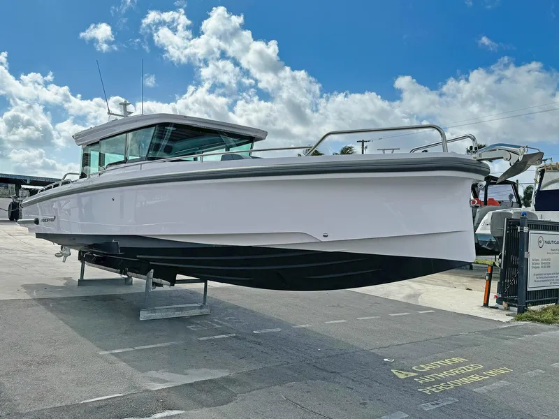 Slide: The Image of 2024 Axopar 37XC CROSS CABIN boat displayed outdoors under a blue sky. - 23