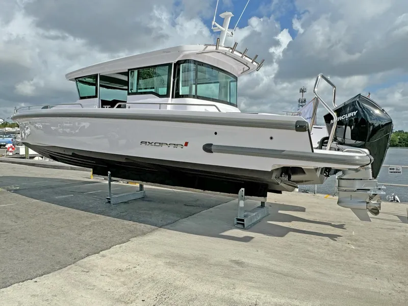 Slide: The Image of 2024 Axopar 37XC CROSS CABIN boat on display at a marina. - 6