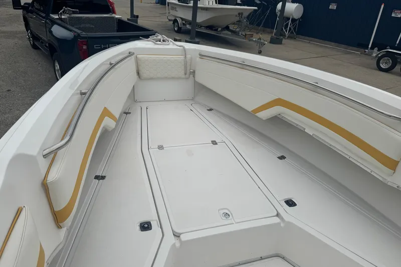 Slide: The Image of 2004 Fountain 31 Sportfish CC Open Bow with white and yellow seating, docked near a truck. - 10