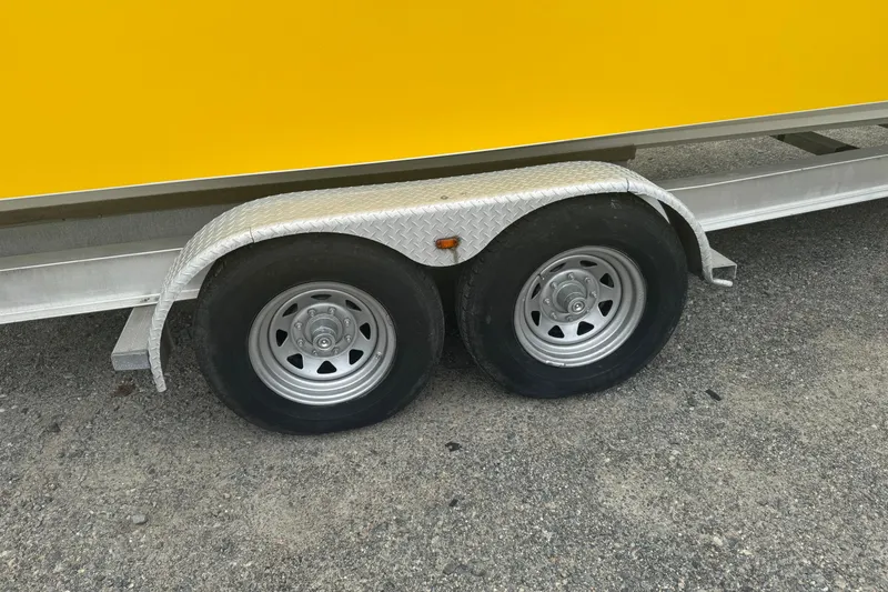 Slide: The Image of Trailer with dual wheels and yellow boat, Fountain 31 Sportfish CC Open Bow, 2004 model. - 25