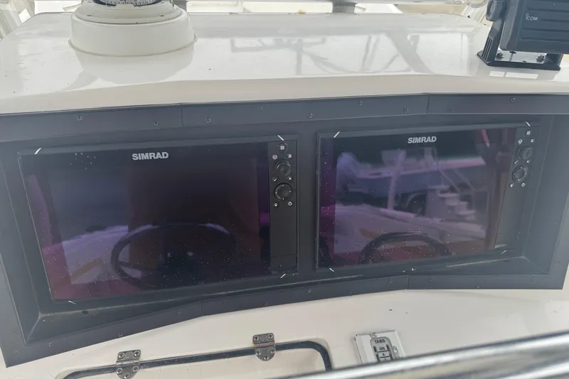 Slide: The Image of Dual Simrad displays on a 2004 Fountain 31 Sportfish CC Open Bow boat dashboard. - 5