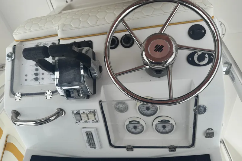 Slide: The Image of 2004 Fountain 31 Sportfish CC Open Bow helm with steering wheel and controls. - 7