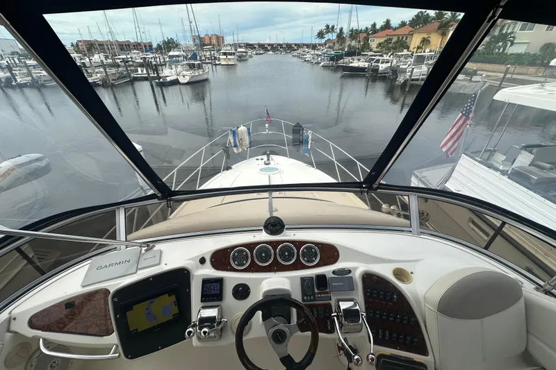 Slide: The Image of 2005 Meridian 459 Motoryacht helm view at marina, featuring Garmin navigation system. - 11