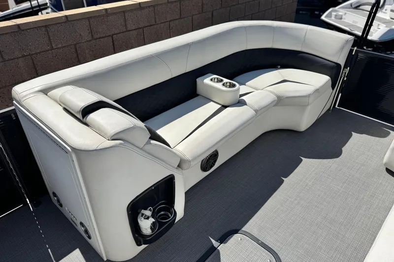 Slide: The Image of 2021 Manitou 25 LX SHP boat interior with luxurious seating and cup holders. - 10