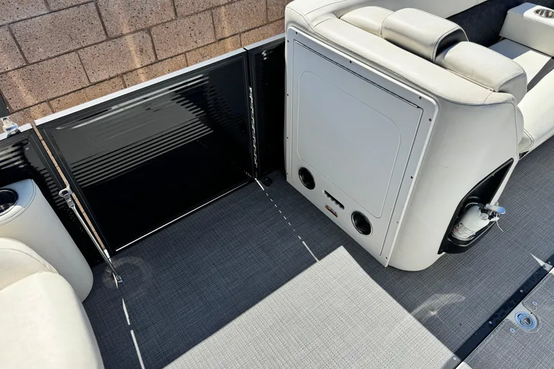 Slide: The Image of 2021 Manitou 25 LX SHP boat interior with seating and storage compartments. - 13