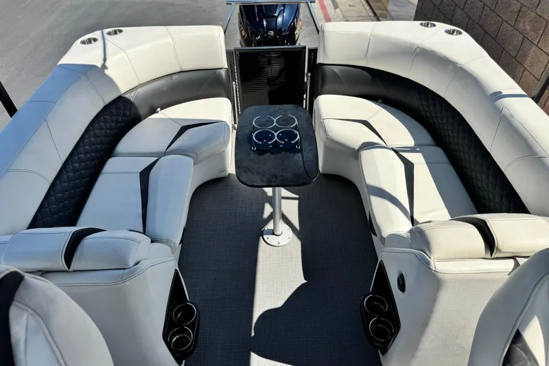 Slide: The Image of 2021 Manitou 25 LX SHP boat interior with luxurious seating and cup holders. - 18