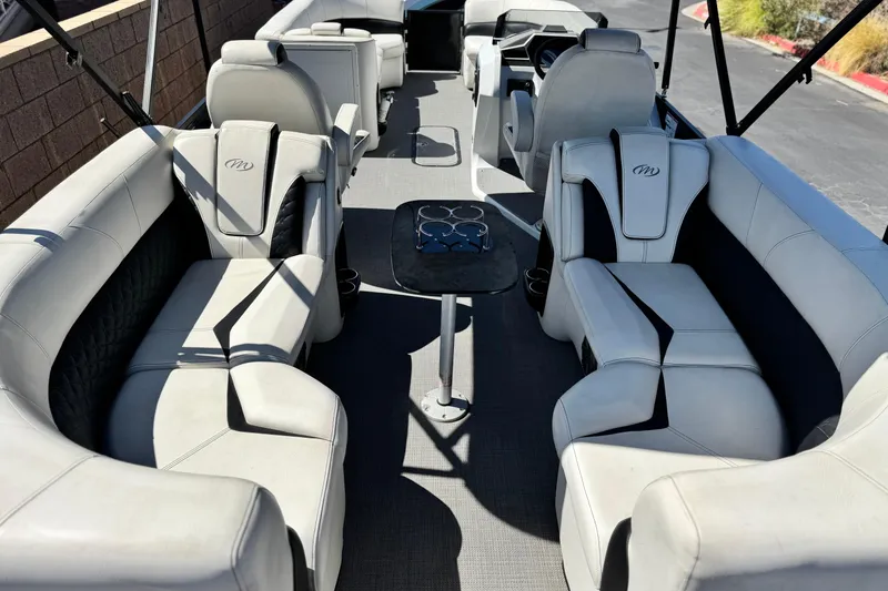 Slide: The Image of 2021 Manitou 25 LX SHP pontoon boat interior with luxurious seating and table. - 20
