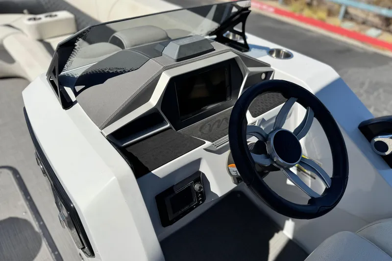 Slide: The Image of 2021 Manitou 25 LX SHP boat dashboard with steering wheel and control panel. - 24