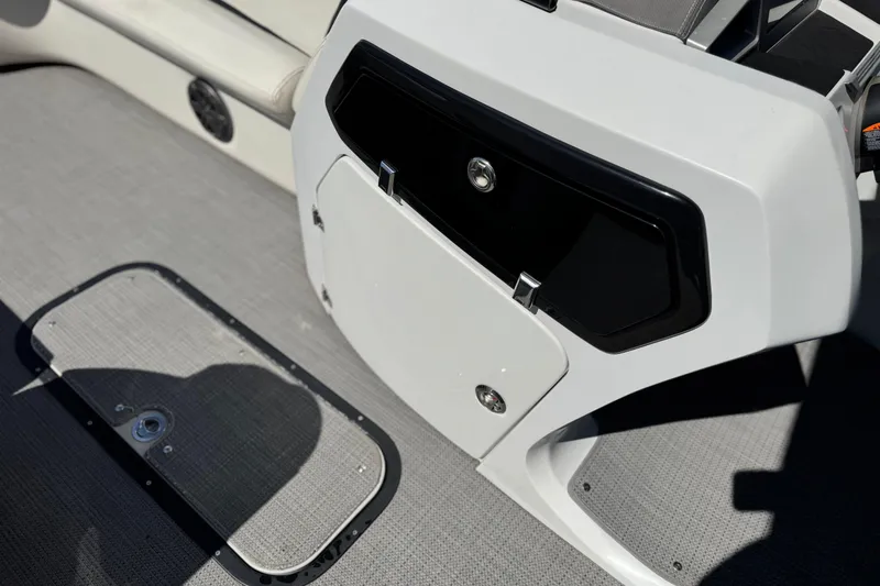 Slide: The Image of 2021 Manitou 25 LX SHP boat interior with storage compartment and speaker. - 25