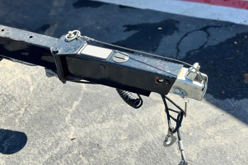 Slide: The Image of Trailer hitch of a 2021 Manitou 25 LX SHP on pavement background. - 28