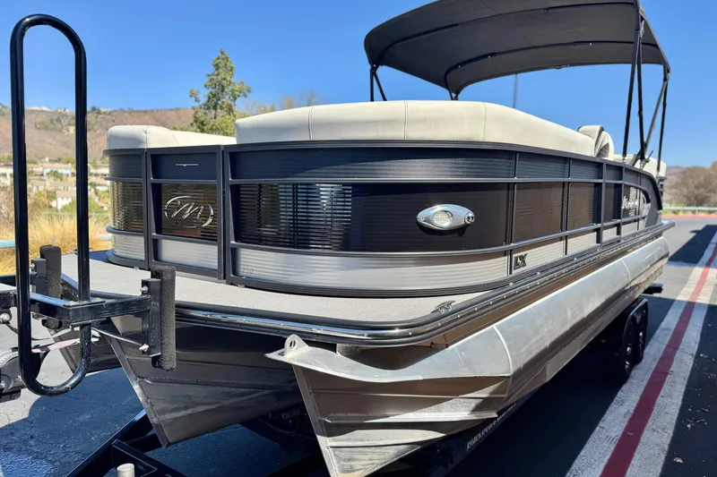 Slide: The Image of 2021 Manitou 25 LX SHP pontoon boat on trailer, sunny day background. - 3