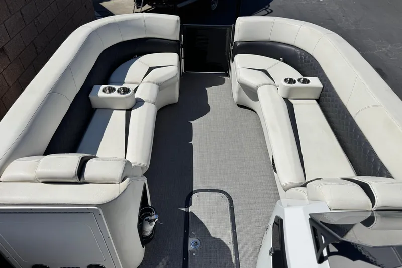 Slide: The Image of 2021 Manitou 25 LX SHP pontoon boat interior with plush seating and cup holders. - 9