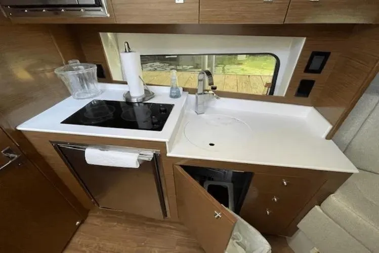 Slide: The Image of 2018 Cruisers Yachts 390 Express Coupe kitchen with stove, sink, and storage. - 11
