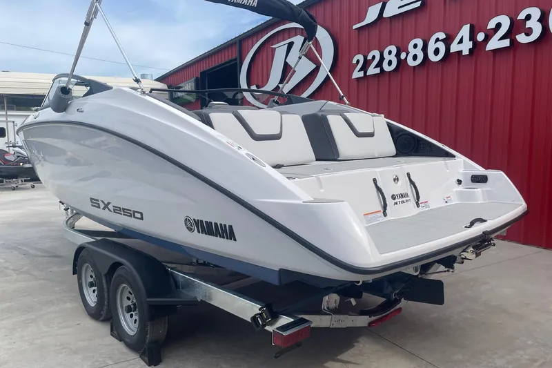 Slide: The Image of 2024 Yamaha Boats SX250 on trailer, displayed outside a dealership. - 2