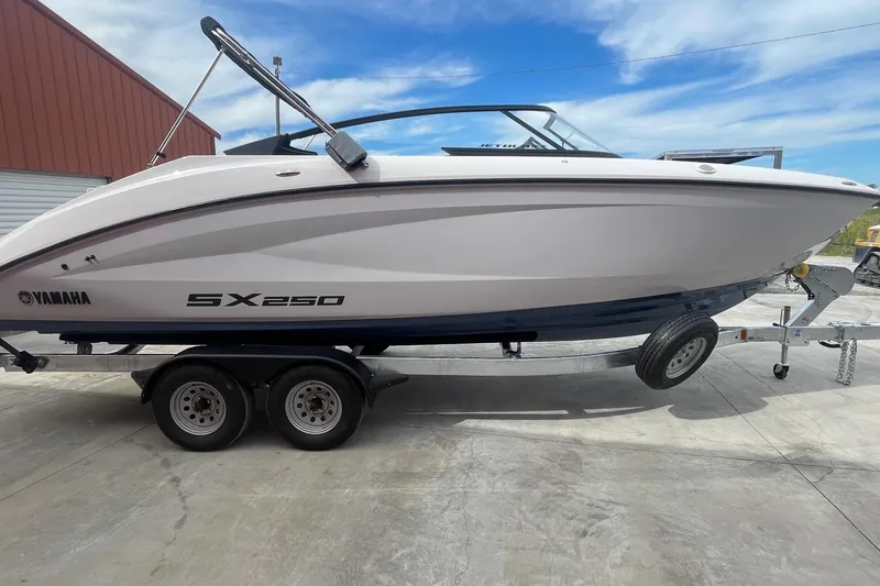 Slide: The Image of 2024 Yamaha Boats SX250 on trailer, sleek design, parked outdoors. - 6