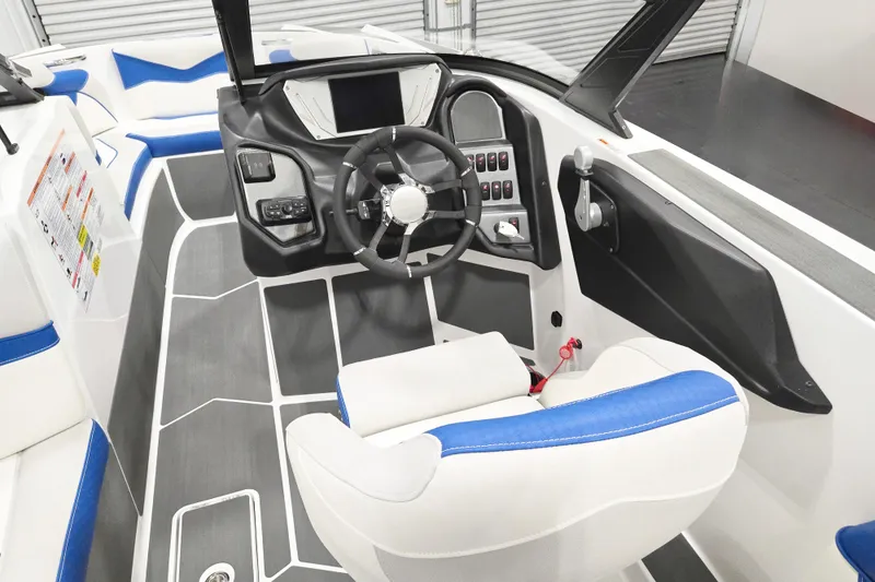 Slide: The Image of 2026 Supreme S220 boat interior with modern dashboard, steering wheel, and blue-accented seating. - 7