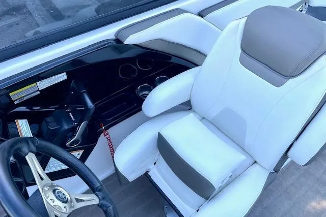 Slide: The Image of 2015 Yamaha Boats 242 Limited S cockpit with white and beige seating and steering wheel. - 12