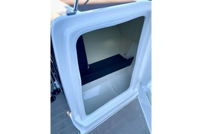 Slide: The Image of 2015 Yamaha Boats 242 Limited S storage compartment, open and empty. - 13