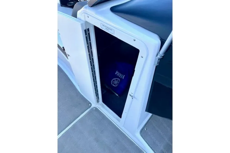 Slide: The Image of 2015 Yamaha Boats 242 Limited S storage compartment with Yamaha-branded item inside. - 14